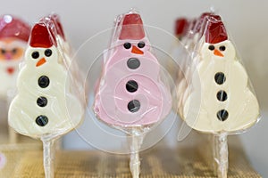 Snowman lollipops. Snowman cake pops. Snowman made of sugar candies. Merry Christmas and happy New Year greeting card photo