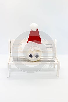 Snowman made of a ball on a banch on white background.Winter Christmas Holiday concept