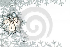Snowman meringue in snowflake plate and silver gray snowflakes isolated on white background