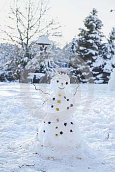 Snowman in the middle of the yard, children`s entertainments, winter fun,