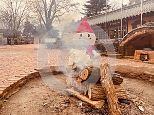 Snowman next to campfire in Korea