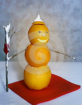 snowman from oranges with broom and cream