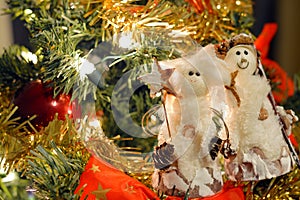 Snowman ornaments and bows in Christmas tree