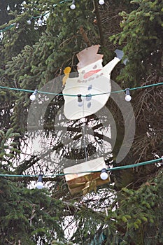 snowman and a present wrapped box hanging from a christmas tree