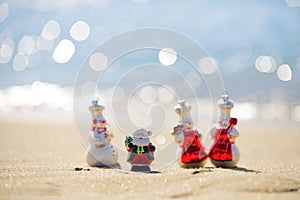 Snowman in santa hat on the sea beach. New Year and Christmas holidays. Santa Claus gifting gift. Festive header design