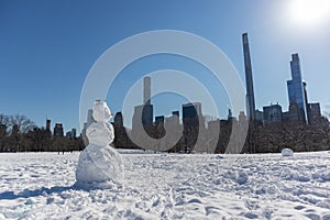 Snowman on the Sheep Meadow at Central Park in New York City during the Winter with the Midtown Manhattan Skyline in the Backgroun