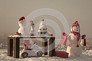 Snowman with shopping bags on grey sky background