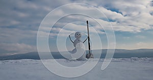 Snowman with snow shovel. Snowman on the snow outdoor background. Christmas banner with snowman. New year greeting card