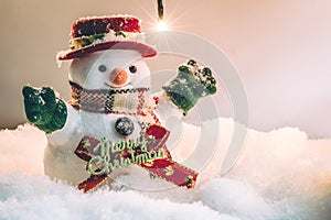 Snowman stand among pile of snow at silent night with a light bulb