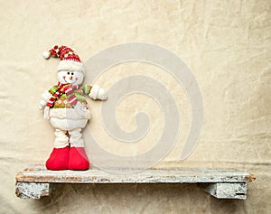 snowman toy on a shelf, christmas banner, copy space for promo or ad