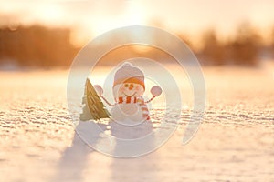 Snowman in winter wonderland scene. Christmas, New Year postcard design. Wintertime magic. Snowman in december snow at sunset