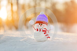 Snowman in winter wonderland scene. Christmas, New Year postcard design. Wintertime magic. Snowman in december snow at sunset