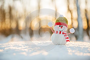 Snowman in winter wonderland scene. Christmas, New Year postcard design. Wintertime magic. Snowman in december snow at sunset