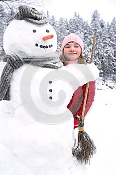 Snowman and a young girl outside in snowfall