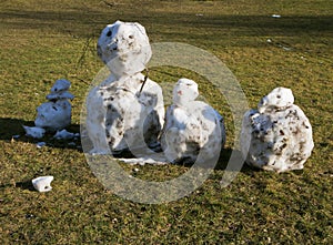Snowmen made with snowballs and decorated by twigs on a sunny da