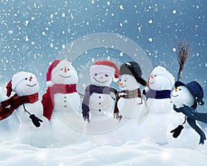 Snowmen standing in winter Christmas landscape