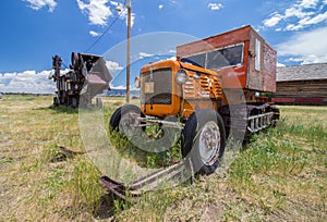 A snowmobile from a bygone age, complete with tracks and skis, rests on the prairie.