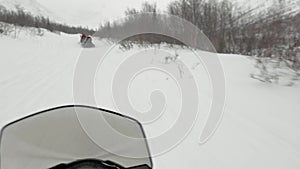 Snowmobile follows speeding snow banana boat with tourists