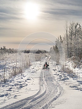 Snowmobile heading into sunlight.