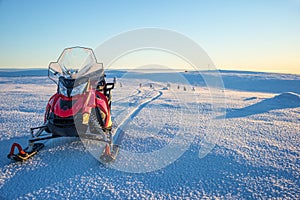 Snowmobile in a snowy landscape in Lapland near Saariselka, Finland photo