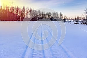 Snowmobile track in snowlandscape. Winter time background