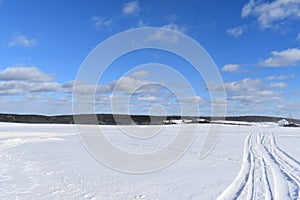 Snowmobile tracks under a blue sky