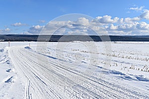 A snowmobile trail under a blue sky