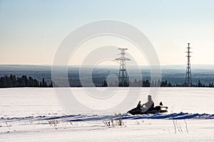 Snowmobiler rides on a snow field.