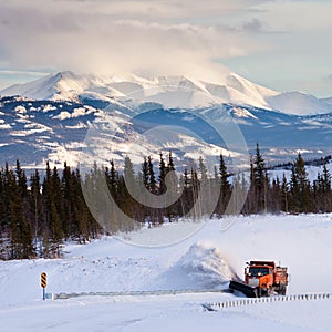 Snowplow clearing road in scenic Yukon T Canada