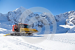 Snowplow in the mountains prepairing piste