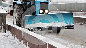 Snowplow moving on the road in the city along the bridge