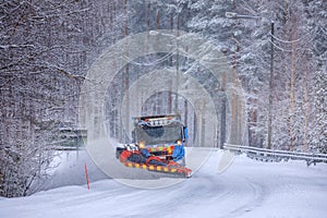 Snowplow truck clearing a snow-covered icy road