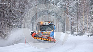 Snowplow truck clearing a snow-covered icy road