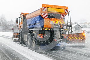 Snowplow truck removing dirty snow from city street or highway during heavy snowfalls. Traffic road situation. Weather forecast