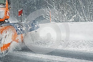 Snowplow truck removing dirty snow from city street or highway after heavy snowfalls. Traffic road situation. Weather forecast for