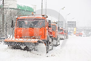 Snowplow trucks removing snow on the road street during blizzard snowstorm in Moscow, Russia.