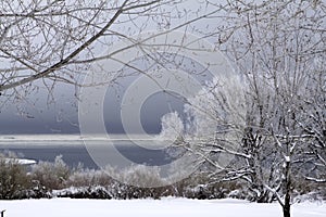 Snowscape with lake and stormy sky