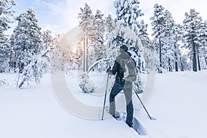 Snowshoe hiker walking in the snow. Outdoor winter sport activity and healthy lifestyle concept.