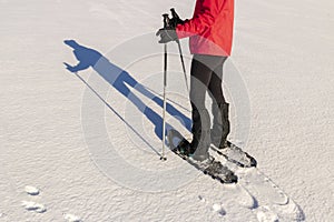 Snowshoeing - woman trekking with snowshoes