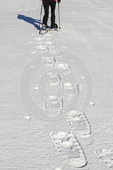 Snowshoeing - woman trekking in winter mountains