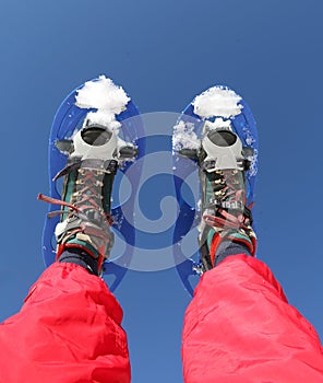 Snowshoes and Red Ski suit in the mountains photo