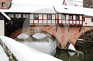 Snowstorm in old town Nuremberg, Germany - Executioner House over river Pegnitz