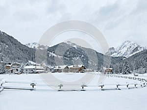 Snowy alpine village in Italy with mountains in the background