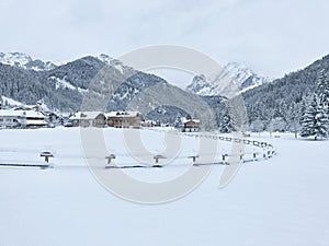 Snowy alpine village in Italy with mountains in the background