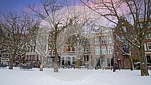 Snowy Amsterdam houses in winter in the Netherlands at sunset