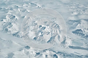 Snowy arctic mountain ridges and river valley scenic aerial landscape on sunny winter day