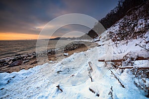 Snowy beach in Gdynia Orlowo at sunrise, Baltic Sea. Poland