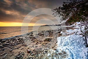 Snowy beach in Gdynia Orlowo at sunrise, Baltic Sea. Poland