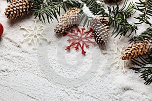 Snowy christmas background with fir branch and pine cones.