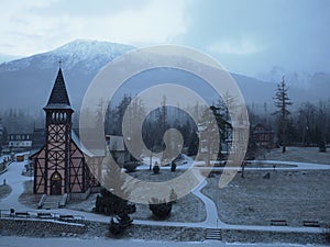 Snowy church and in the background the mountains of the High Tatras in Slovakia